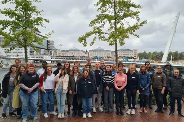 A group of people posing for the photo in an urban setting. Photo.